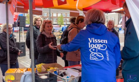 Deelnemer Vissenloop ontvangt route en startbewijs op plein '45 in IJmuiden
